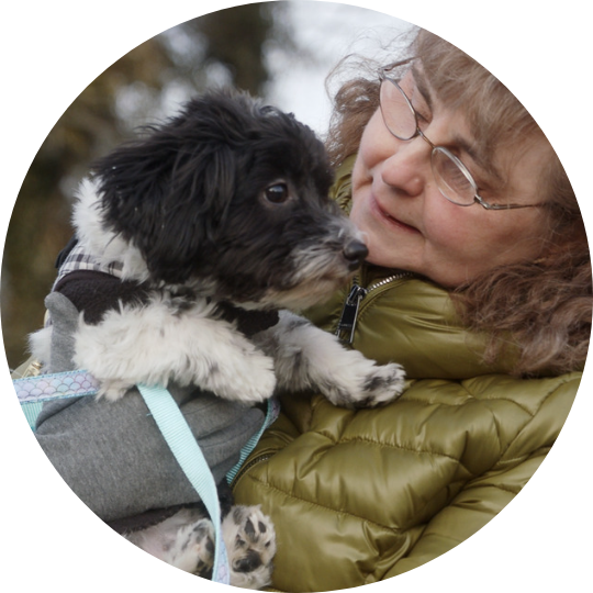 Black and white puppy being held by Paul's sister, Norma Jean.